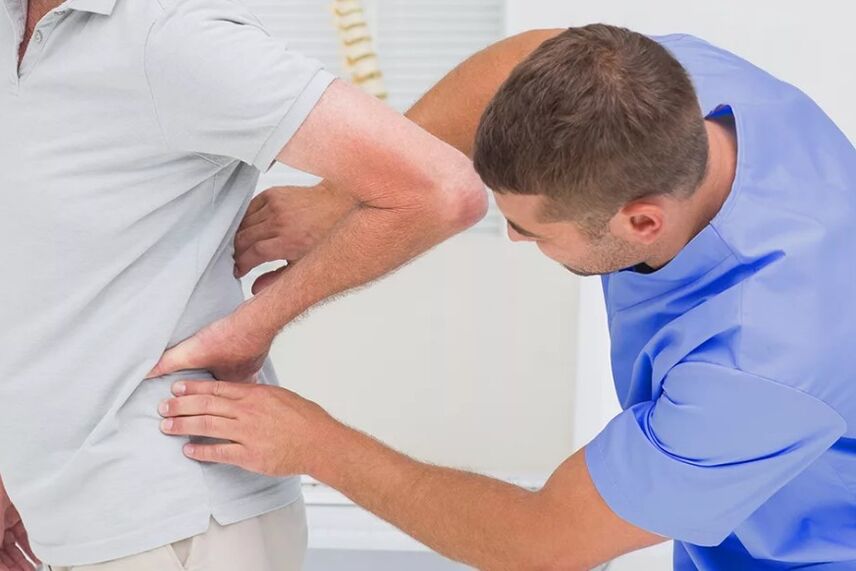 A patient with lower back pain during a diagnostic examination by a doctor